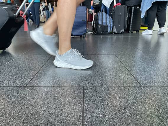 Person pulling a suitcase seen from legs down