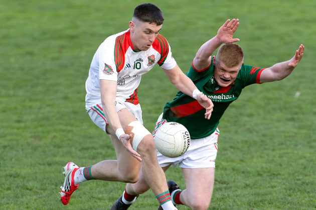 Suncroft forward Eoghan Lawless solo's his way through the attempted block down from Kevin Byrne of Milltown 