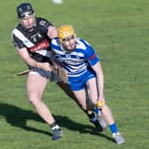 Naas wing-forward Oisin O'Neill holds off the tackling Cathal McCabe of Maynooth before laying off his hand pass