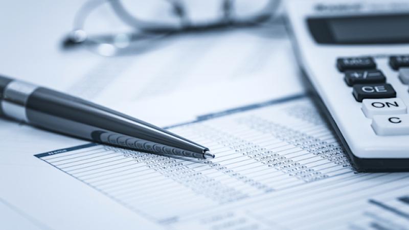 Accounting financial audit bank banking account stock spreadsheet data with glasses pen and calculator in washed blue monochrome financial concept for analysis, audit finance forensics