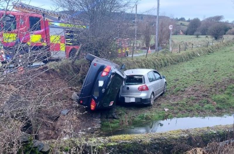 PHOTOS: Two cars skid on black ice and crash into field 