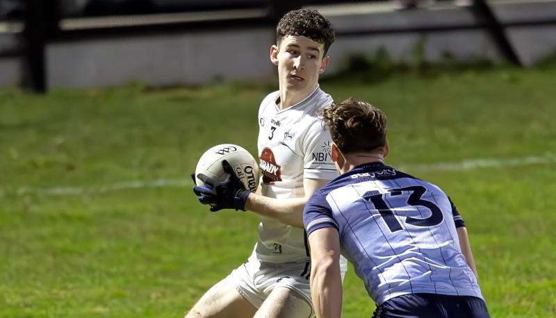 Pauric Spillane holds in possession as Jamie McCarville moves in