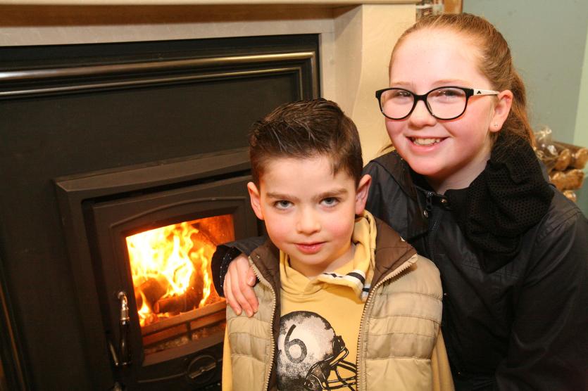 Aaron and Aoibhe Lee beside a warm Henley stove.