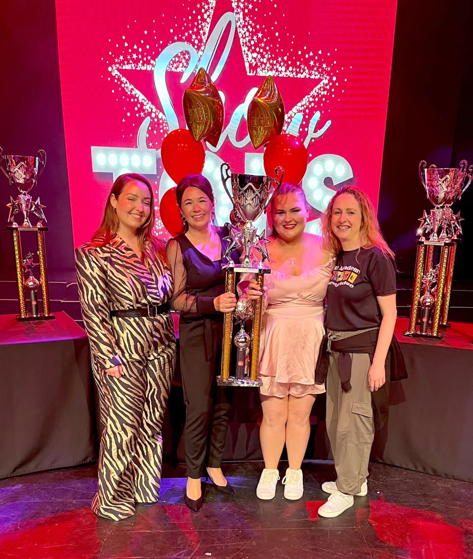 Kim Shortall (Director of ShowTops), Lisa Price (ShowTops Judge) present Stage Academy vocal coaches Fiona Ryan and Caoimhe Gately with the winning trophy